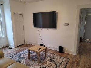 a living room with a flat screen tv on the wall at Two-Bedroom Home 25 min to NYC Free parking-UNIT-1 in Teaneck