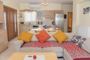 a living room with a couch and a kitchen at Shell & Pebble in Acharavi