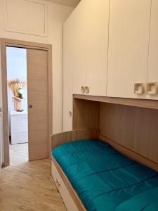 Dormitorio pequeño con cama con manta azul en Dea Bendata, en Palestrina