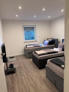 a room with three beds and a television in it at SG Apartment in Essen