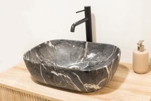 a black bathroom sink on a wooden counter at El Rincon de Marieta in Huesca +9 photos