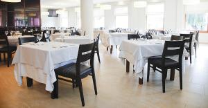 a dining room with tables and chairs with white table cloth at Hotel Mar de Plata in Sarria