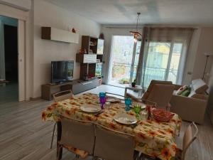 杜比诺Tra lago e montagne home nonna Maria的一间带桌椅的客厅和一间餐厅