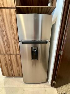 a stainless steel refrigerator in a kitchen with wooden cabinets at El Firmamento 36f in Mezcales
