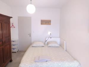 una camera da letto con un letto con un libro sopra di T2 avec grand balcon filant, Wifi, Clim à 4 min Remparts ad Avignone