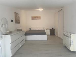 una camera bianca con letto e cassettiera di Wohlfühloase 2 Casa Elena und Gerd a Città di Rodi