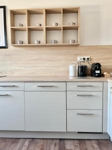 a kitchen with white cabinets and white counters at Anne in Sankt Pölten