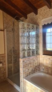 a bathroom with a tub and a glass shower at La Solana in Ancillo
