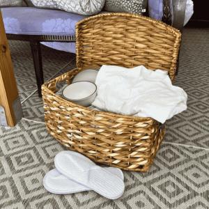 a basket with white towels and a pair of slippers at Outdoor Adventure Retreats - Wilderness Cove Campground in Saluda