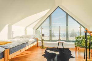 a bedroom with a bed and a large window at Domki z Widokiem Klikuszowa jacuzzi in Klikuszowa