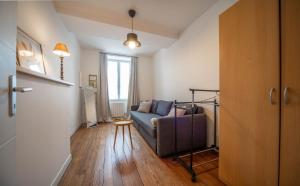 a living room with a couch and a window at Le refuge citadin in Tournus +2 photos