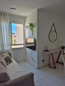 a living room with a couch and a table and a mirror at Condomínio Residencial Serigy in Aracaju