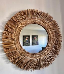 a wicker mirror on a wall with two pictures at Apartamento La casa Verde in Punta Prima