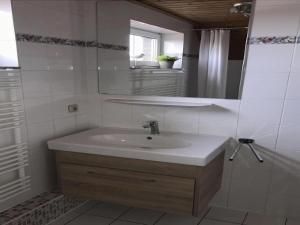 ein weißes Badezimmer mit Waschbecken und Spiegel in der Unterkunft Holiday Home in Butjadingen near Wadden Sea in Burhave