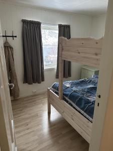a bedroom with a bunk bed and a window at Comfortable house in Gryllefjord in Senja