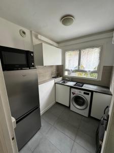 a kitchen with a refrigerator and a washing machine at Studio moderne à paris in Gentilly