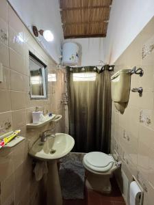Un baño con inodoro, lavabo y ducha. en Angelita sobre playa, en Aguas Dulces