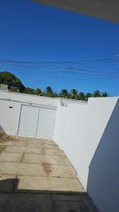 a white building with two garage doors on it at Casa inteira próximo ao Cumbuco e Fortaleza in Caucaia