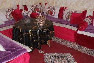 a living room with a table and a couch at Grand appartement fabuleux in Agadir