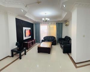 a living room with a couch and a table at Two- Bedroom Masaki Sea View Retreat in Dar es Salaam +1 photo