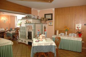 a kitchen with two tables and a stove in it at Albergo Ginevra in Roncone