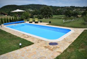 a large swimming pool in a yard with a grass field at Pansion Savinac in Takovo
