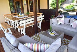 a living room with a couch and a table and chairs at Pansion Savinac in Takovo