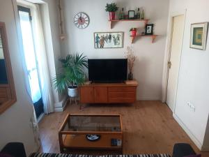a living room with a tv and a coffee table at Apartamento OGUM Cáceres in Cáceres