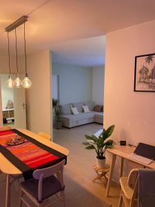a living room with a table and a couch at Appartement Très Cosy à 5 min Aéroport Genève in Ferney-Voltaire +42 photos