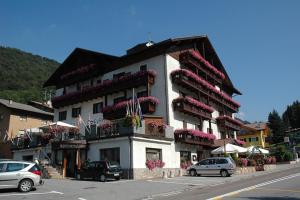 a building with flowers on the balconies on a street at Albergo Ginevra in Roncone