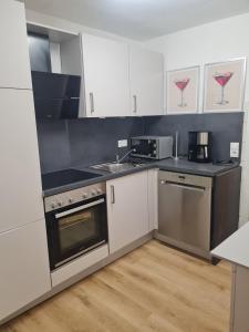 a kitchen with white cabinets and black counter tops at Ferienwohnung mit Burgblick in Mayen
