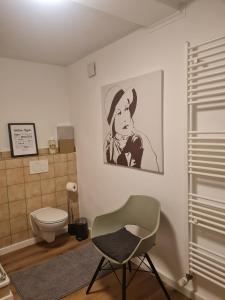 a bathroom with a toilet and a chair in it at Ferienwohnung mit Burgblick in Mayen