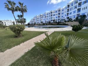a park with palm trees and a large building at Marinasmir Jawhara in Fnidek