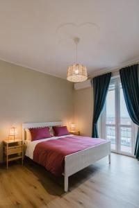 una camera da letto con un letto grande e una grande finestra di Green house ad Alessandria