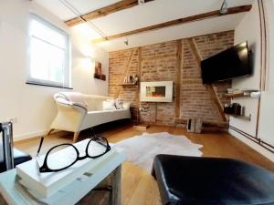 a living room with a white couch and a brick wall at Hof Eckens - Ferienhaushaus Marie in Wildeck Bosserode in Wildeck