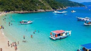a group of people in the water at a beach at Suíte Varanda Vist Mar Sonho do Pontal Arraial do Cabo in Arraial do Cabo +4 photos