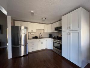 a kitchen with white cabinets and a stainless steel refrigerator at The Perfect Restful Retreat in Wareham