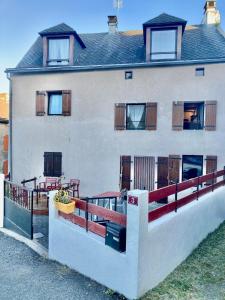 a white house with a porch and a balcony at Charmante maison au coeur d'un village auvergnat in Saint-Diéry