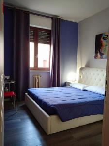 a bedroom with a king sized bed with blue walls at Le Stanze di Marco in Monza