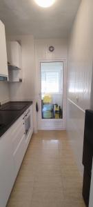 a kitchen with white cabinets and a window at Casa Dolores in Puerto de Mazarrón