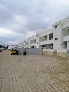 un estacionamiento con un coche amarillo delante de un edificio en CostaSud Rita's House, en Bari