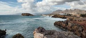 a view of a beach with rocks in the water at Casa Dolores in Puerto de Mazarrón