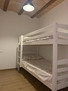 a bedroom with two bunk beds and a light at Casa Rural con Encanto in Tirig