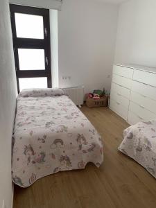 a bedroom with a bed with a comforter on it at Casa Rural con Encanto in Tirig