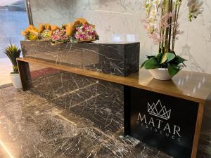 Ein Tisch mit Blumen auf einer Theke in der Unterkunft Matar Residence Hotel Suites in Al Bawsharīyah