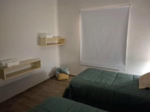a bedroom with a green bed and a window at Rincón de paso in Ciudad Lujan de Cuyo