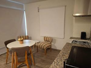 a living room with a table and chairs and a white screen at Rincón de paso in Ciudad Lujan de Cuyo