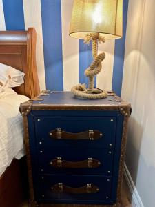 a blue dresser with a lamp on it next to a bed at Sea Ayr - City Centre Apartment in Ayr