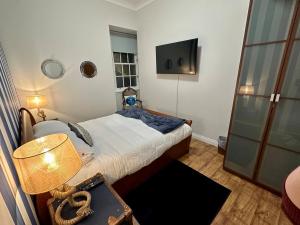 a small bedroom with a bed and a television at Sea Ayr - City Centre Apartment in Ayr