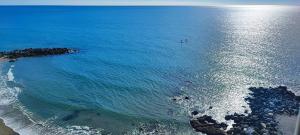 una vista aérea del océano con gente en el agua en Primera línea de playa Benalmádena La Perla Playa Paraíso, en Benalmádena